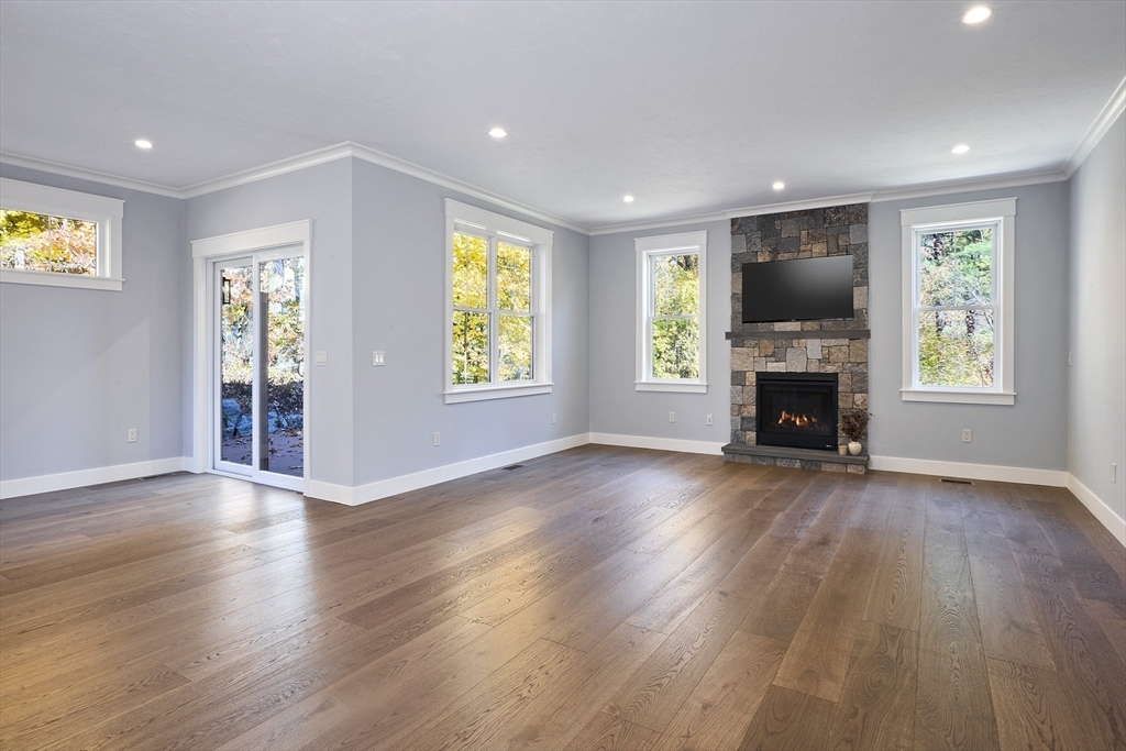 1 Thomas Drive Acton, MA 01720 - Photo 15 of 36 an empty room with windows fireplace and wooden floor