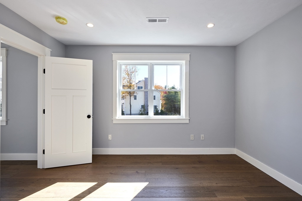 1 Thomas Drive Acton, MA 01720 - Photo 22 of 36 a view of an empty room with wooden floor and a window