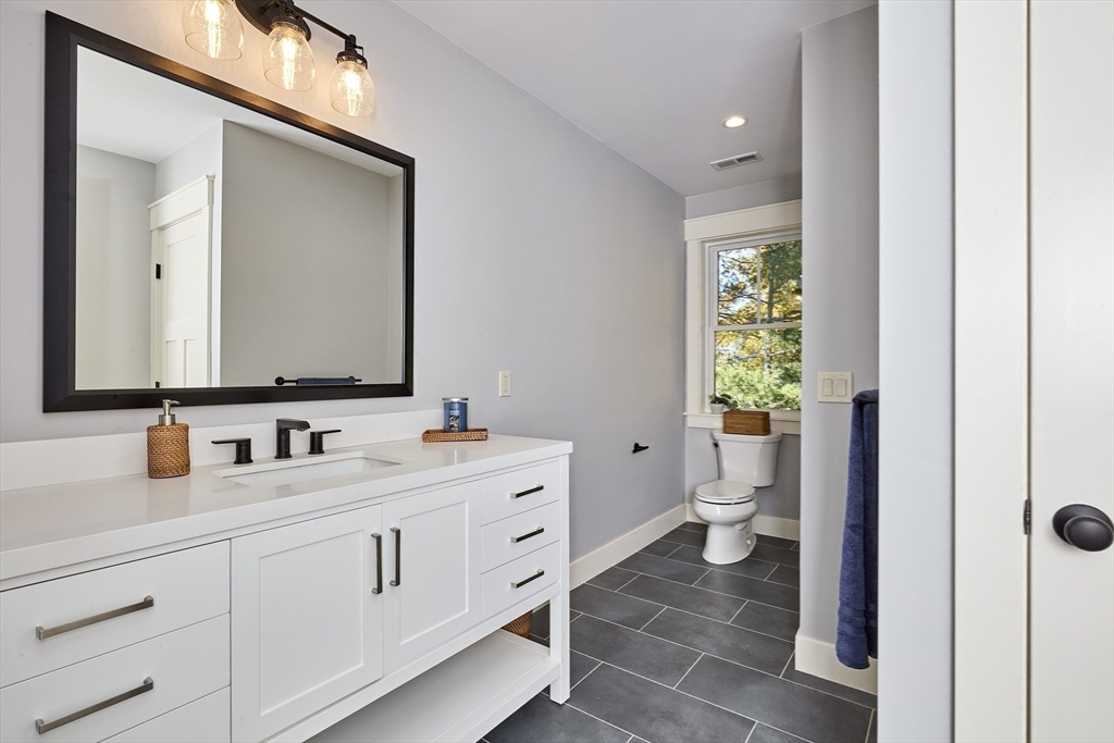 1 Thomas Drive Acton, MA 01720 - Photo 33 of 36 a bathroom with a double vanity sink toilet and a mirror