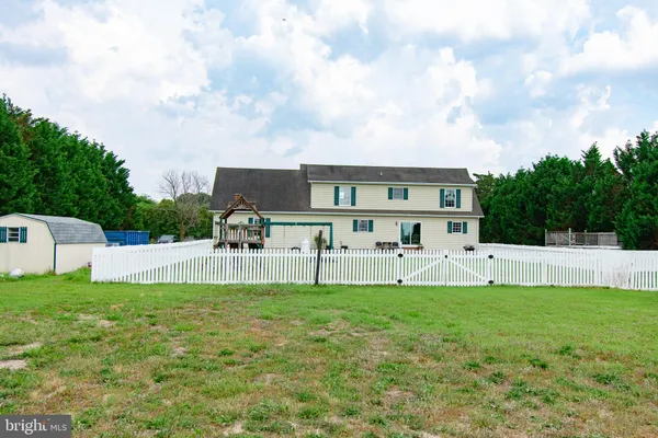 a view of a house with a big yard and large trees