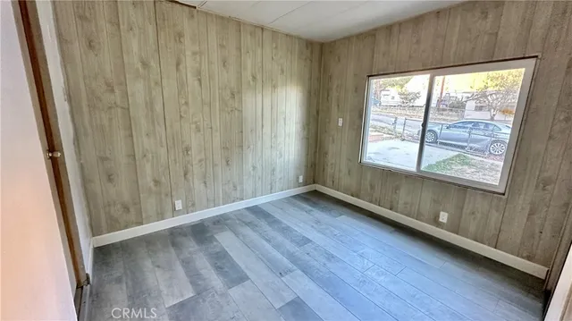 a view of a hallway with wooden floor and a glass door