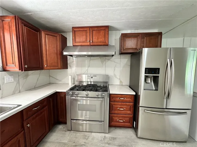 a view of kitchen with refrigerator and window