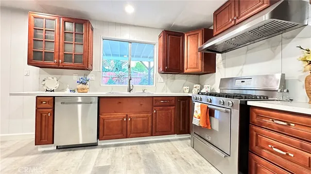 a view of kitchen with stainless steel appliances granite countertop a refrigerator and a sink