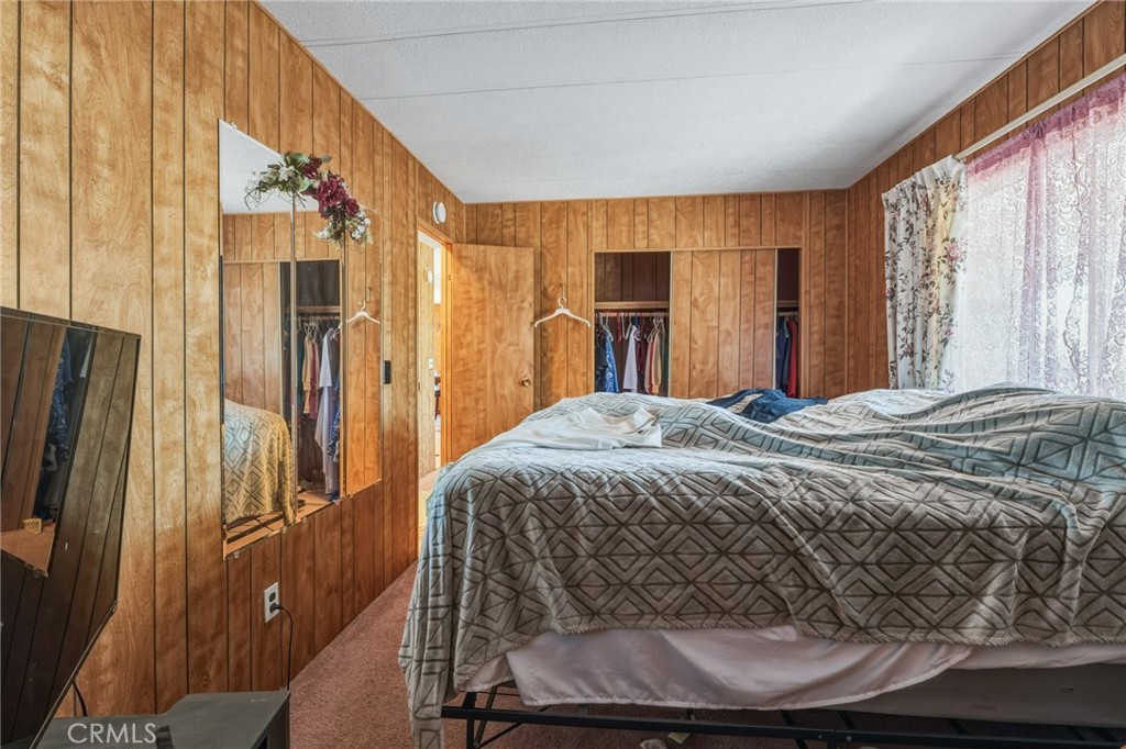 20683 Waalew Road, Unit B201 Apple Valley, CA 92307 - Photo 19 of 32 a bedroom with a bed a window and walk in closet