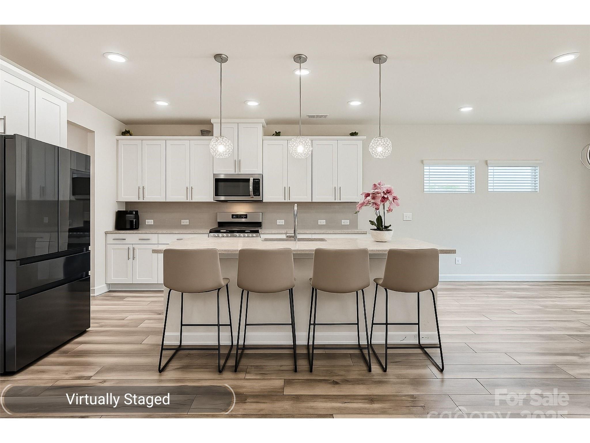a kitchen with stainless steel appliances kitchen island granite countertop a sink and a refrigerator