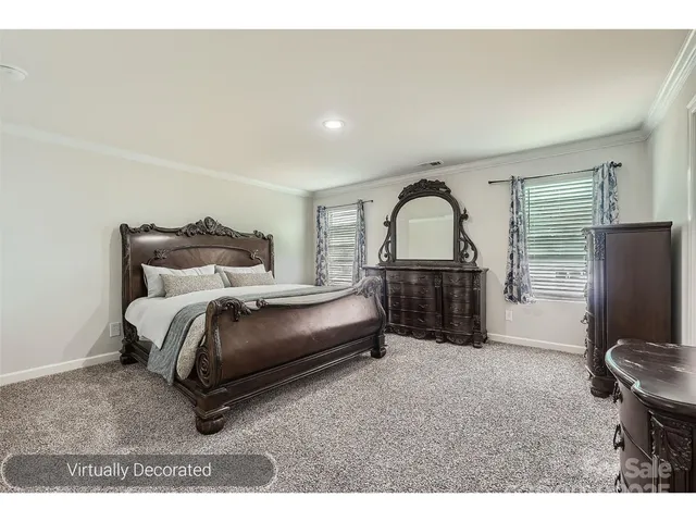 a bedroom with a bed a mirror and dresser