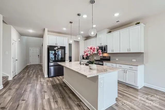 a kitchen with kitchen island a sink stove and refrigerator