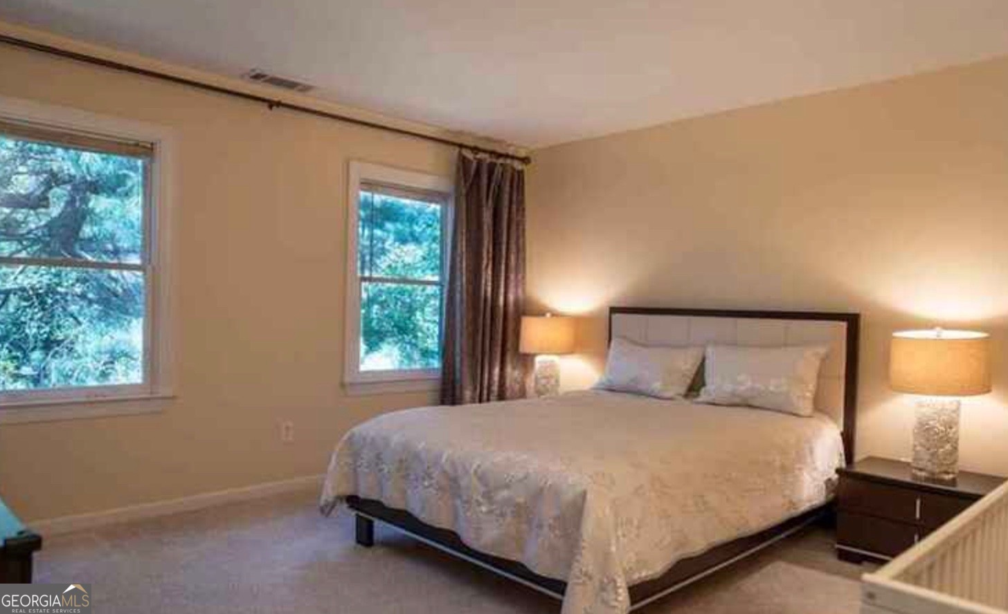 212 Abingdon Way Northeast Sandy Springs, GA 30328 - Photo 11 of 21 a large bed sitting in a bedroom next to a window
