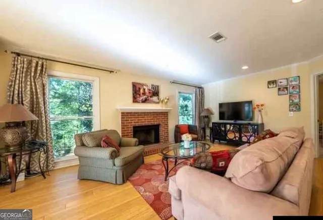 a living room with furniture fireplace and a large window