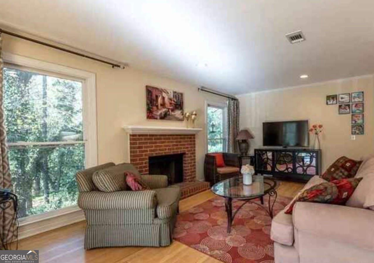 212 Abingdon Way Northeast Sandy Springs, GA 30328 - Photo 5 of 21 a living room with furniture a flat screen tv and a fireplace