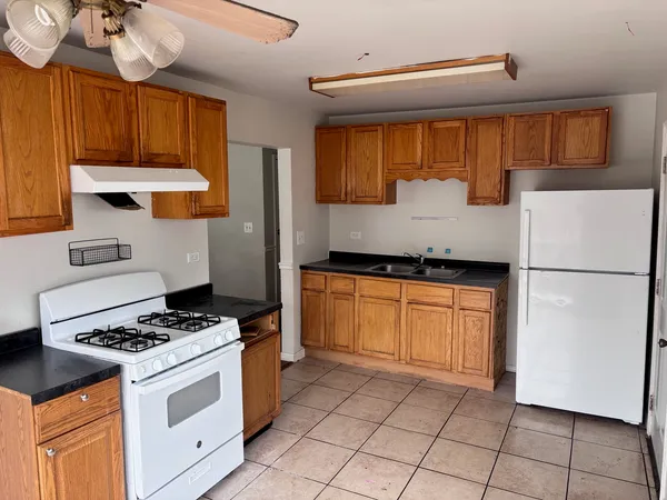 a kitchen with granite countertop a stove sink and cabinets