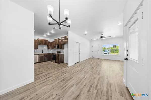 a view of a kitchen with a sink and wooden floor
