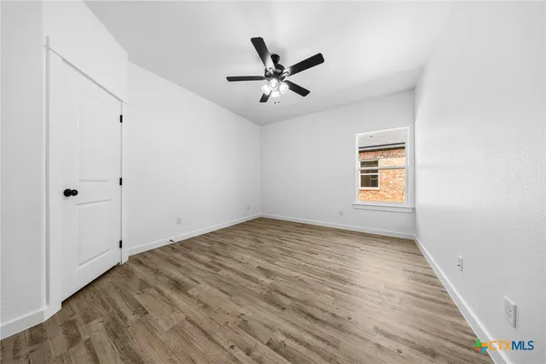 a view of a livingroom with a ceiling fan and wooden floor