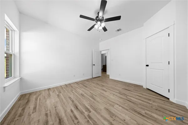 a view of empty room with wooden floor