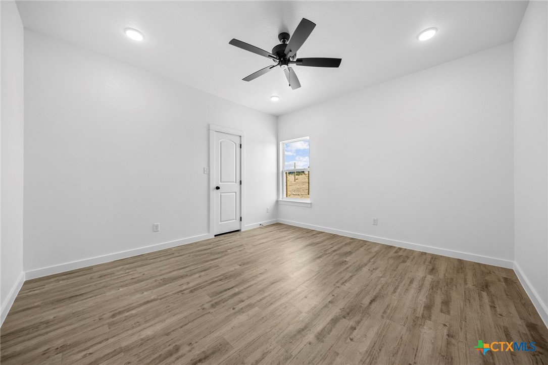 3604 Canvasback Road Killeen, TX 76542 - Photo 23 of 27 an empty room with wooden floor and ceiling fan