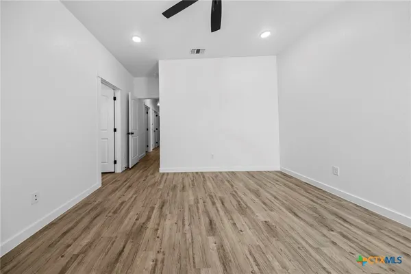 a view of a room with wooden floor staircase and a kitchen