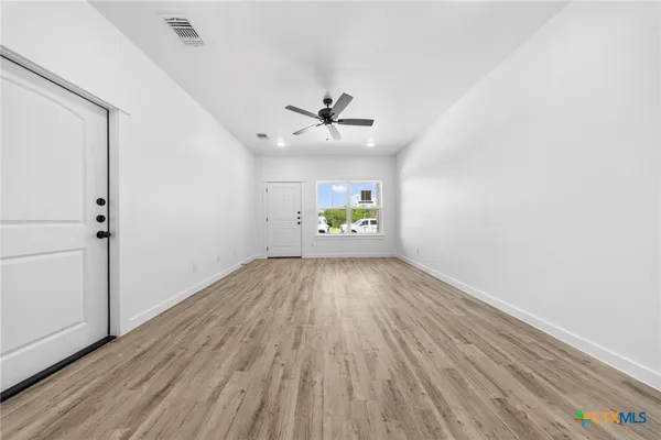 wooden floor in an empty room with a window