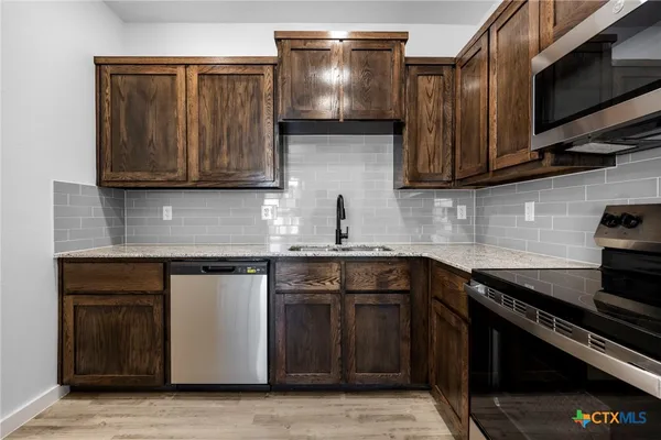 a kitchen with stainless steel appliances granite countertop a stove and a sink