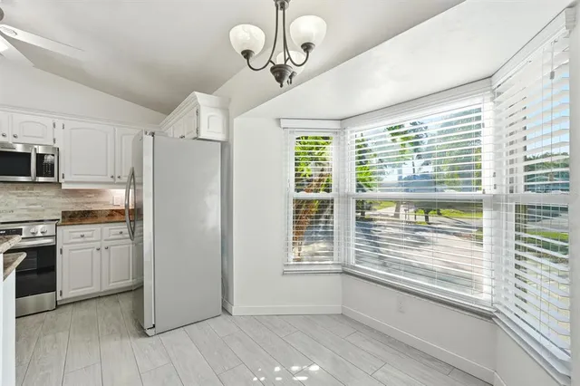 a kitchen with stainless steel appliances hardwood floor sink and window