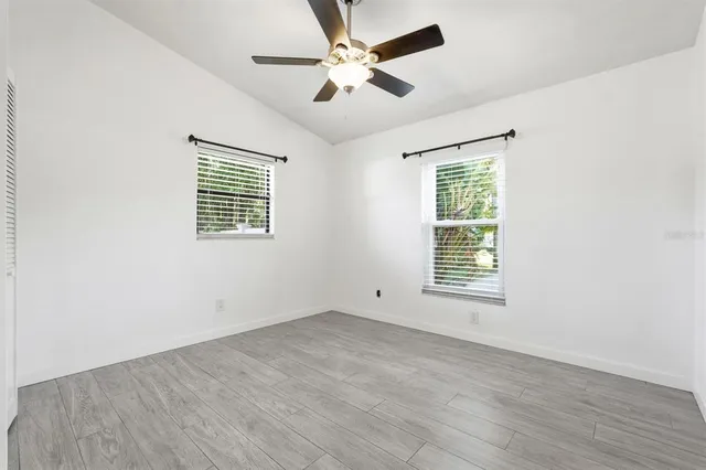 a view of an empty room with a window and a ceiling fan