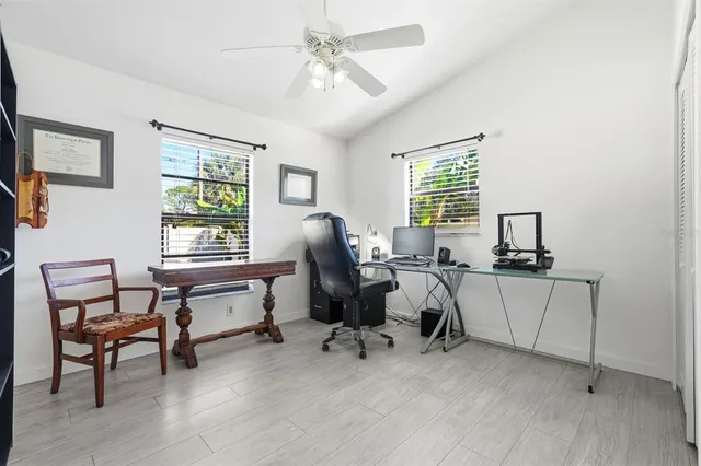 a view of a workspace with furniture and a window