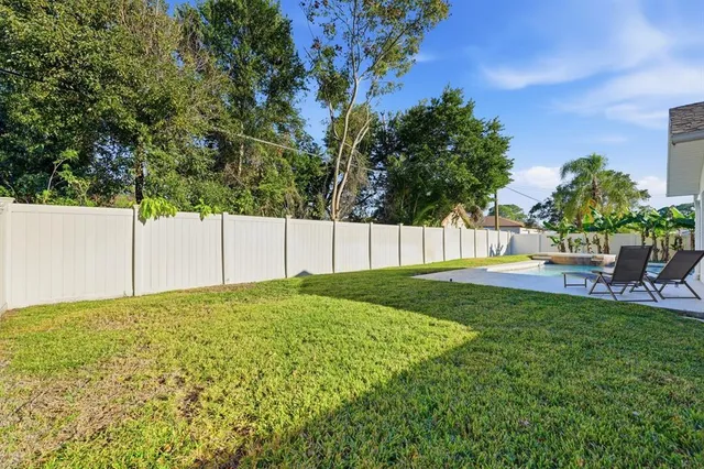 an aerial view of residential houses with outdoor space and trees
