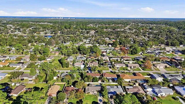 an aerial view of residential houses with outdoor space and trees