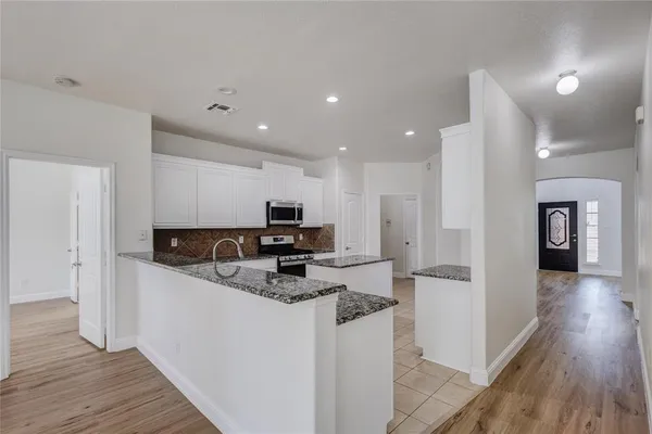 a kitchen with kitchen island a sink stainless steel appliances and cabinets