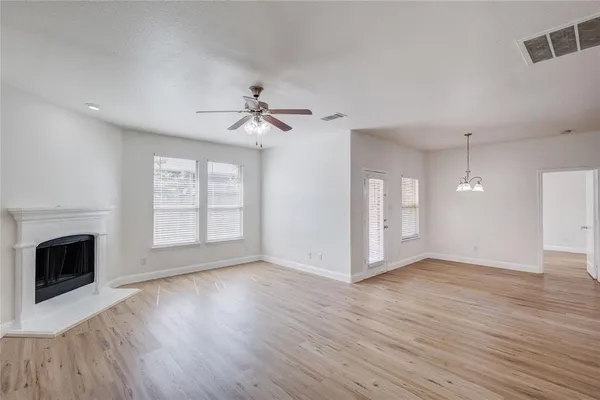 a view of an empty room with a fireplace and a window