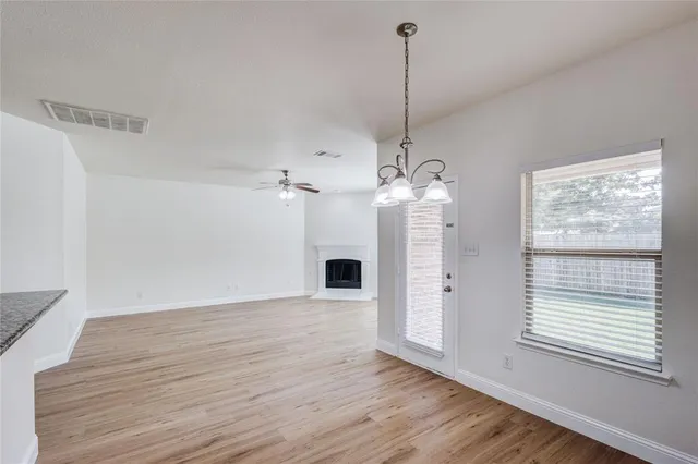 a view of a livingroom with a chandelier wooden floor front door and furniture