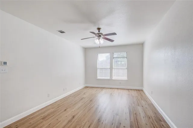 an empty room with wooden floor and window