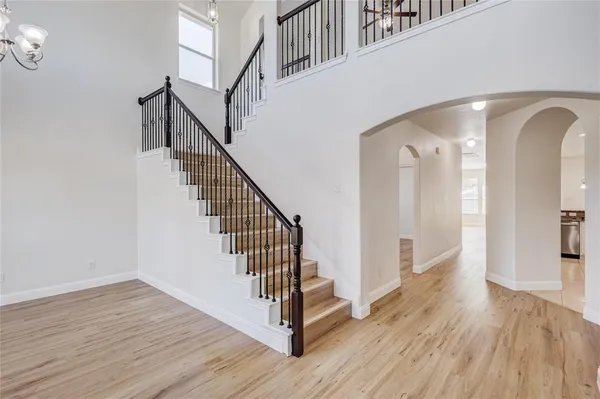 a view of a hallway with wooden floor and staircase