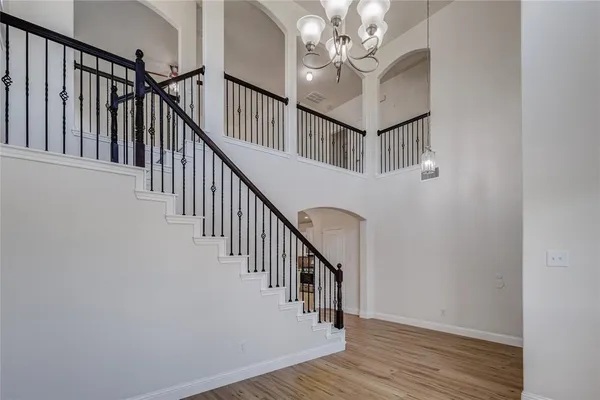 a view of staircase with wooden floor and fan