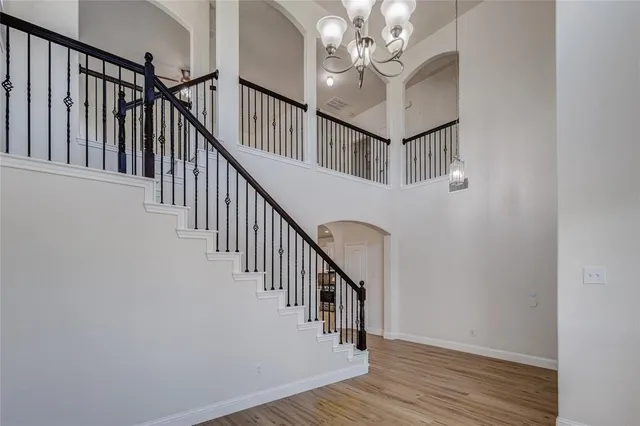 a view of staircase with wooden floor and fan