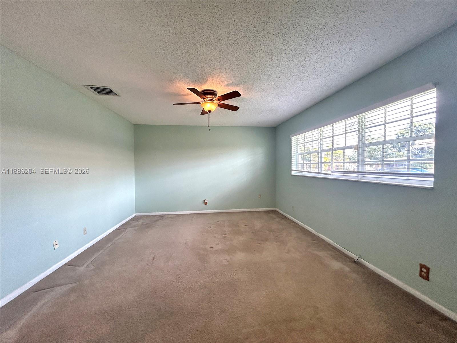 6520 Southwest 20th Street Plantation, FL 33317 - Photo 11 of 43 an empty room with windows and chandelier fan
