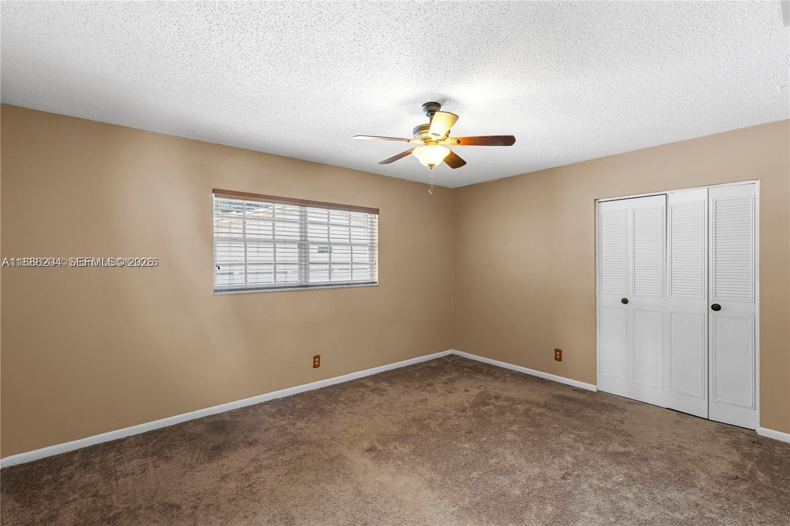 6520 Southwest 20th Street Plantation, FL 33317 - Photo 24 of 43 an empty room with a window and ceiling fan