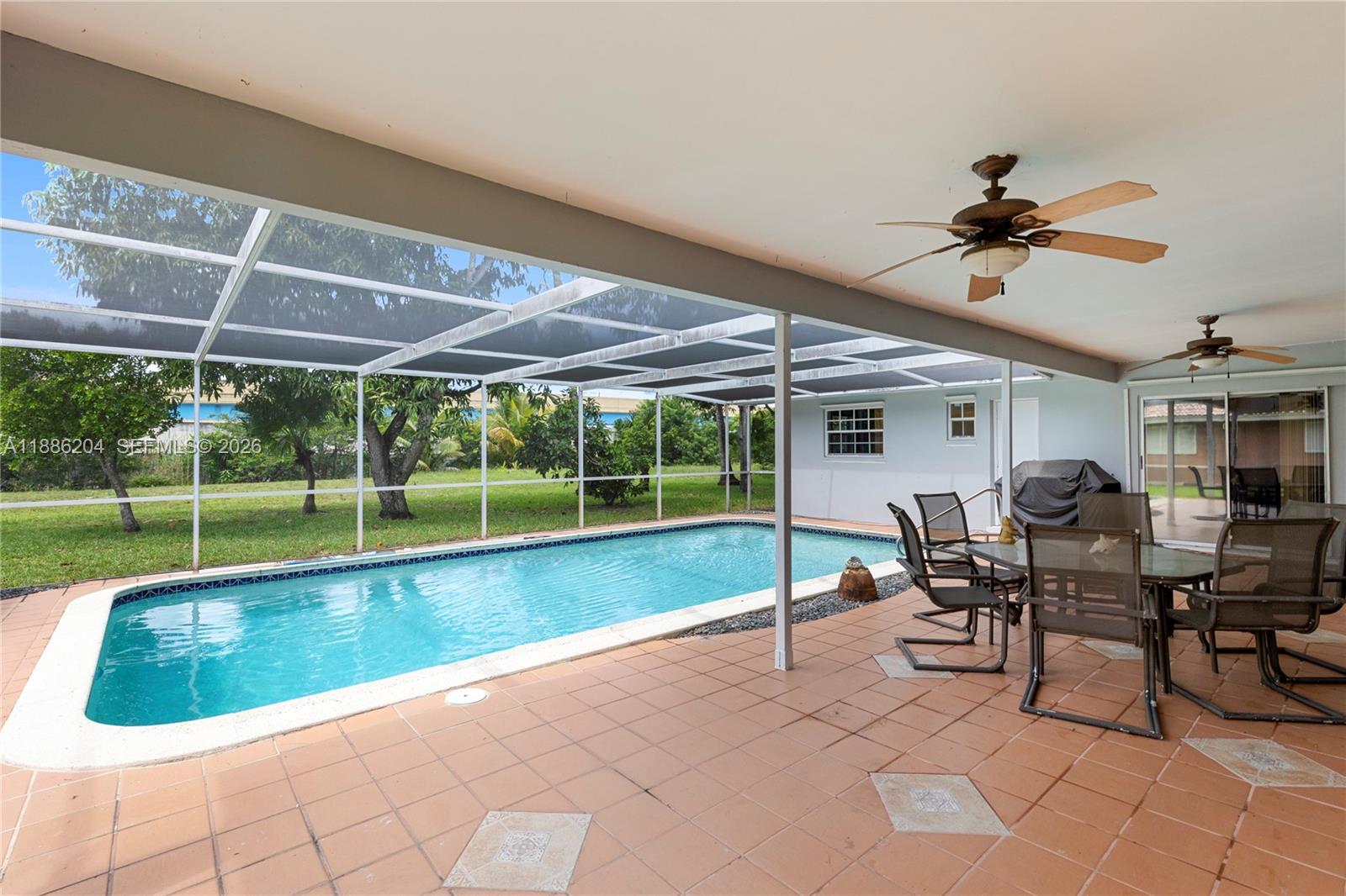 6520 Southwest 20th Street Plantation, FL 33317 - Photo 32 of 43 a view of a patio with a table and chairs under an umbrella