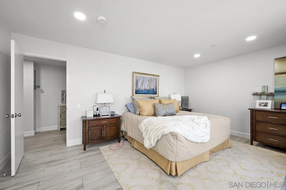 1125 Pacific Beach Drive, Unit 104 San Diego, CA 92109 - Photo 17 of 67 a bedroom with a bed and a lamp on dresser