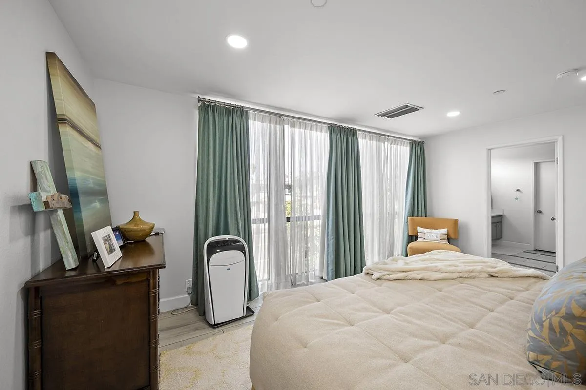 1125 Pacific Beach Drive, Unit 104 San Diego, CA 92109 - Photo 18 of 67 a bedroom with a bed a flat tv screen and dresser
