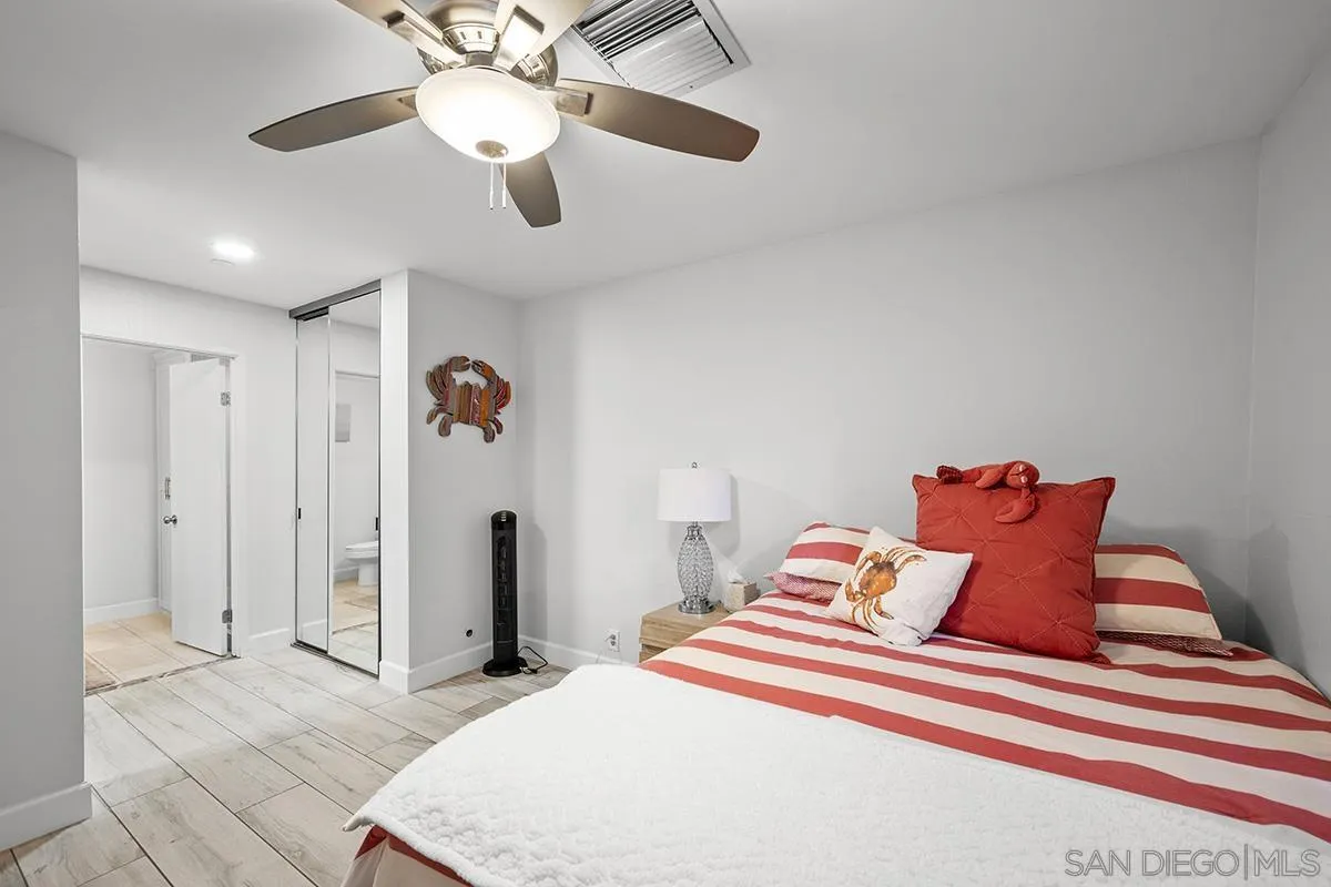 1125 Pacific Beach Drive, Unit 104 San Diego, CA 92109 - Photo 21 of 67 a bedroom with a bed and a chandelier