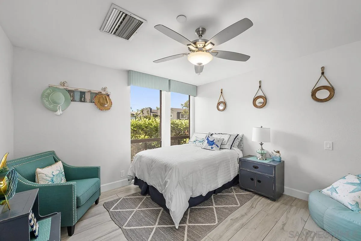 1125 Pacific Beach Drive, Unit 104 San Diego, CA 92109 - Photo 23 of 67 a bedroom with a bed and a chandelier