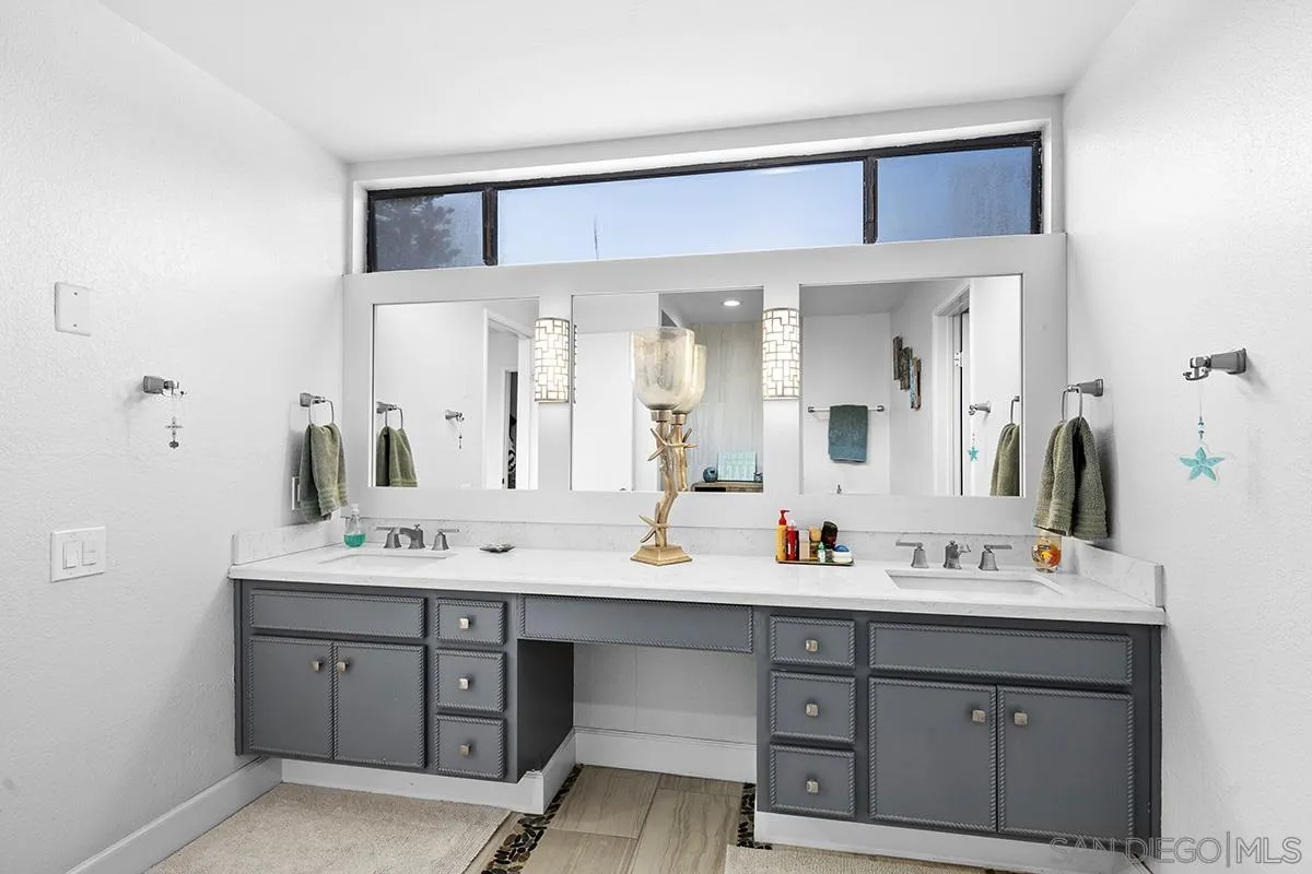 1125 Pacific Beach Drive, Unit 104 San Diego, CA 92109 - Photo 26 of 67 a bathroom with a double vanity sink and mirror