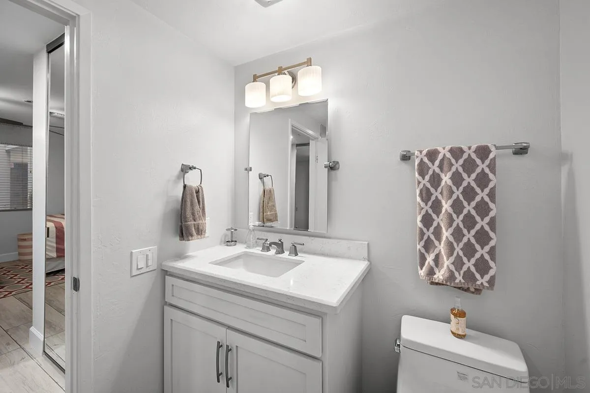 1125 Pacific Beach Drive, Unit 104 San Diego, CA 92109 - Photo 28 of 67 a bathroom with a sink vanity and a mirror