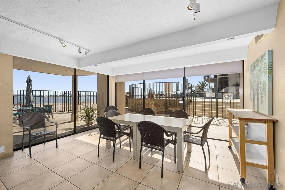 1125 Pacific Beach Drive, Unit 104 San Diego, CA 92109 - Photo 37 of 67 a dining room with furniture and floor to ceiling window