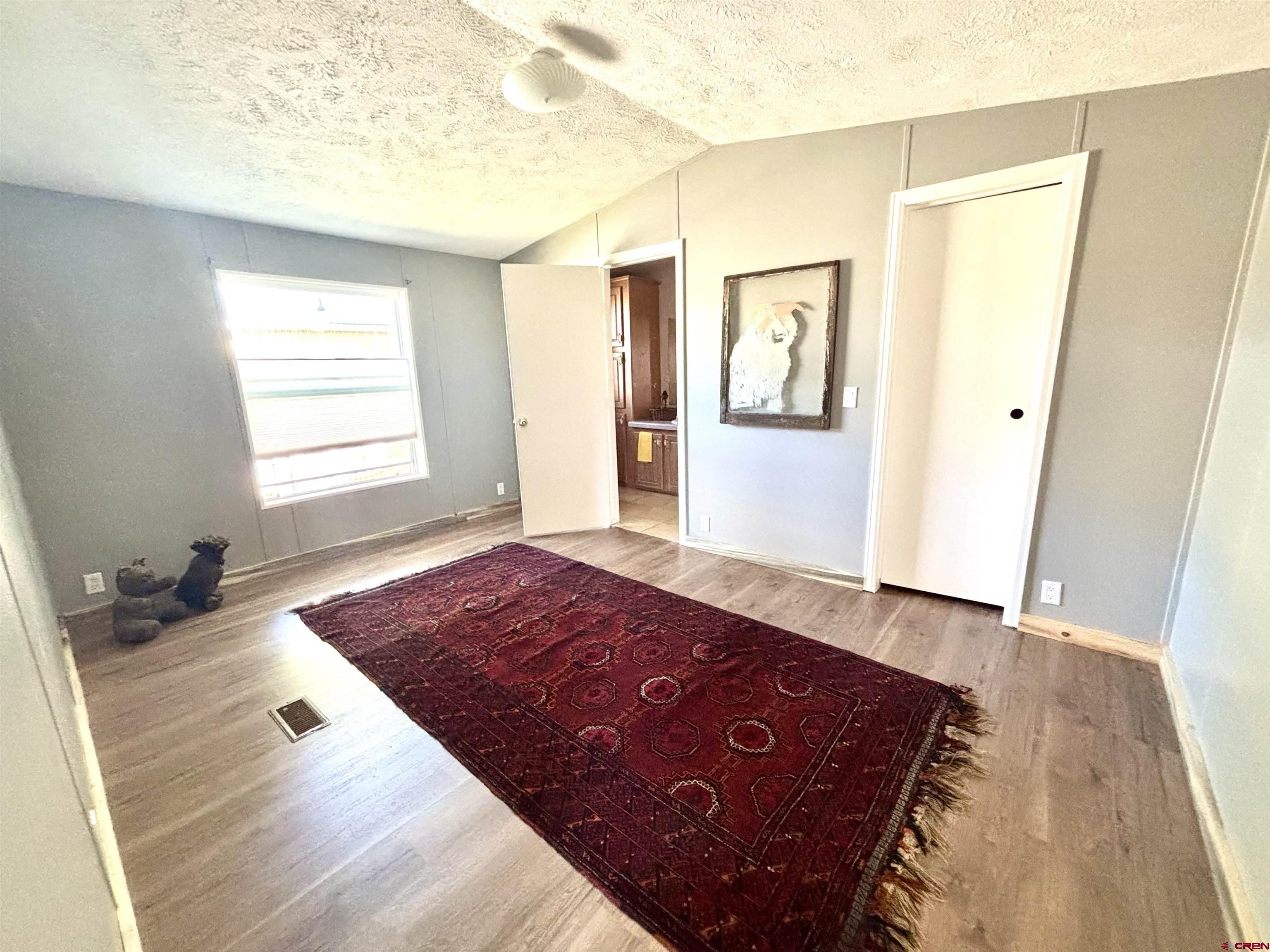 288 Animas View Drive, Unit 9 Durango, CO 81301 - Photo 14 of 16 a bedroom with a bed and wooden floor
