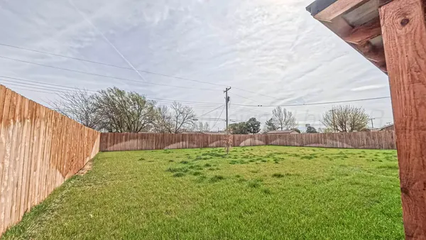 a view of yard with large trees and wooden fence