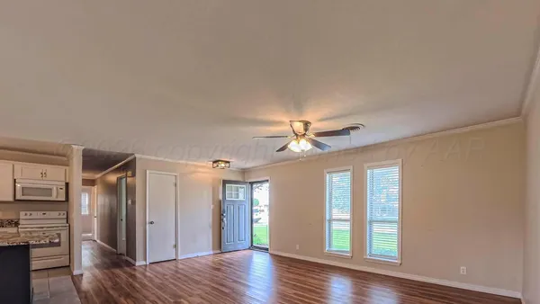 a view of a livingroom with wooden floor and a ceiling fan