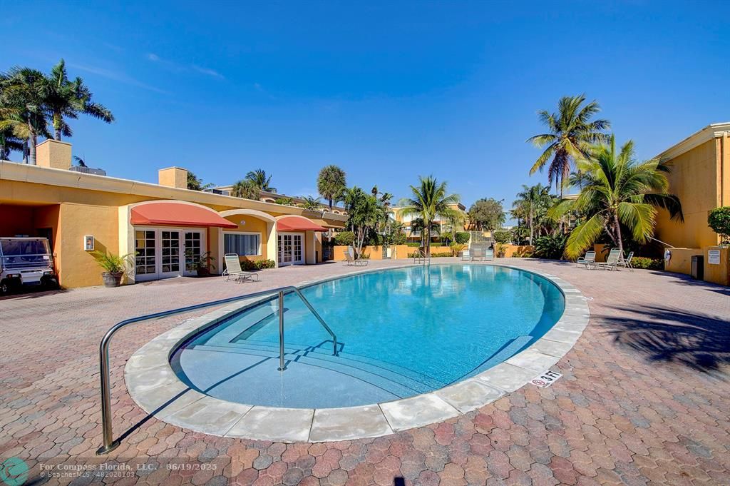 18111 Northwest 68th Avenue, Unit I210 Hialeah, FL 33015 - Photo 16 of 23 a view of a swimming pool with a lounge chairs
