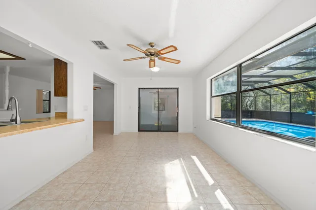 an empty room with fan and windows