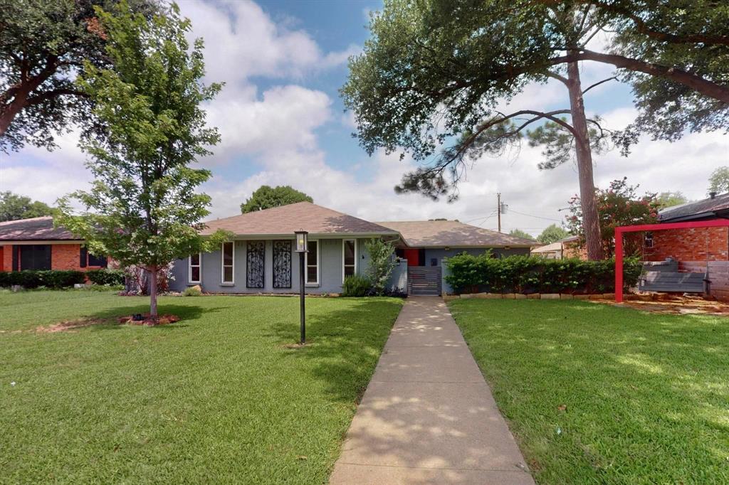 Ranch-style house with a front yard and roof with shingles